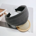 Gros plan du serre-tête en maille côtelée gris foncé sur un support en bois minimaliste - gris foncé