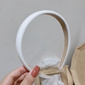 Dettaglio ravvicinato di un cerchietto in raso bianco lucido con fodera antiscivolo - Bianco