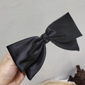 Detalle de la textura satinada sedosa y el nudo elegante del lazo grande negro para el cabello - Lazo Grande Blanco / Negro
