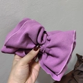 Close-up of purple ribbed knit wide headband showing texture and large bow detail - Purple