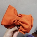 Detail of the oversized orange ribbed knit bow hairband with premium stitching texture - Orange