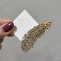 Dettaglio fermaglio per capelli a piuma dorata con strass bianchi brillanti - Strass Oro