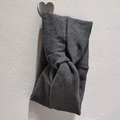 Close-up of grey ribbed knit headband featuring a stylish central twist knot design - Dark Gray