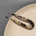 Dettaglio del fermaglio per capelli a forma di U in acetato con motivo tartarugato lucido - Leopardo Chiaro
