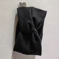 Close-up of black ribbed knit headband featuring a stylish cross twist design details - Black