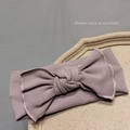 Detail of soft knitted ribbed headband with a large bow in elegant dusty pink color - Pink