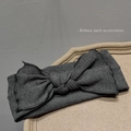 Macro shot of dark grey knitted headband with large bow detail on a stone surface - Dark Gray