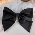 Dettaglio del grande fiocco nero in raso con una texture setosa e lucentezza fine - Fiocco