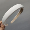 Dettaglio macro del cerchietto imbottito in tessuto con trama bianca e fodera marrone - Bianco Latte
