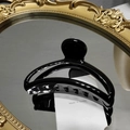 Pinza para el pelo negra brillante en forma de medialuna sobre superficie reflectante - Negro