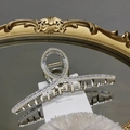 Détail d'une pince à cheveux en alliage argenté avec perles et strass sur plateau miroir - Style Perle et Strass