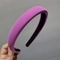 Detail of a thick padded purple headband with a textured fabric finish and black lining - Rose Red