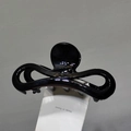 Vue détaillée de la grande pince à cheveux noire brillante avec un design épuré et ressort - Noir