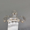 Détail d'une élégante pince à cheveux papillon transparente avec perles dorées - Or champagne