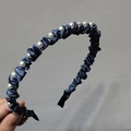 Dettagli di un cerchietto in seta blu scuro con eleganti perle bianche e trama a pieghe fini - Blu