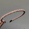 Close-up of pleated leather headband in dusty pink with protective black end caps - Pink