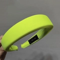Detalle de diadema de esponja amarillo neón con textura de punto y etiqueta artesanal - Amarillo Neón
