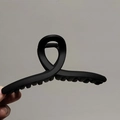 Vue détaillée d'une grande pince à cheveux noir mat avec un design croisé moderne pour femme - Noir