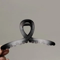 Détail de la pince à cheveux grise mate en dégradé avec un design en boucle torsadée - Noir et Gris