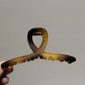 Détail d'une grande pince à cheveux en résine ambrée avec ressort métallique robuste - Ambre
