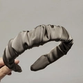 Elegant chocolate brown pleated wide headband in silky satin fabric held by hand - Light Coffee