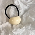 Detalle de adorno de acrílico crema en una goma elástica negra minimalista para el pelo - Blanco Leche