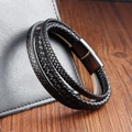 Close-up of black braided leather men's bracelet with magnetic steel clasp on leather bag - 21cm Black