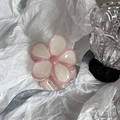 Close-up of a floral hair claw clip in jelly pink and beige on a wavy mirror base - Pink Edged