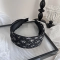 Close-up of black floral fabric headband with delicate purple and yellow flowers - Black