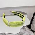 Primo piano di un cerchietto in tessuto plissettato verde lime con doppie file di perle - Lime Neon