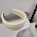 Détail du serre-tête en éponge beige avec texture de tissu épais sur surface réfléchissante - Beige
