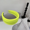 Détail d'un serre-tête large vert néon avec doublure antidérapante sur fond miroir - Jaune Néon