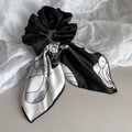 Detail van elegant zwart-wit camellia-patroon op de satijnen haarstrik scrunchie - Roos Bloem