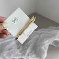 Close-up of minimalist gold metal hair clips on white card over textured fabric - Gold Horizontal Bar