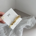 Macro shot of wavy gold alloy hair clips on presentation card for side bangs styling - Gold Large Wave