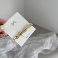 Close-up of two wavy golden alloy hair clips displayed on a branded white card - Gold Small Wave