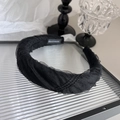 Gros plan du serre-tête en tulle noir avec étiquette faite main sur décor vintage - Noir