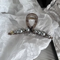 Detail of large brown hair claw clip with grey pearls, black crystals, and gold heart - Gray