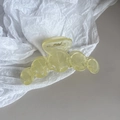 Detail view of a translucent yellow disc hair claw clip with a strong metal spring - Light Yellow