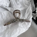 Dettaglio di un grande fermaglio per capelli con strass e perle su carta bianca - Grigio