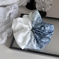 Dettaglio di un grande elastico in raso con pois blu e design patchwork bianco su vassoio - Blu Profondo