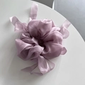 Detail of light purple organza scrunchie with long ribbons on a white surface - Pink