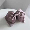 Detail einer eleganten satinierten Haarklammer in Altrosa mit seidiger Struktur - Rosa