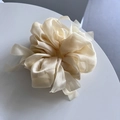 Macro shot of large champagne organza scrunchie with layered pleats on white podium - Light Yellow