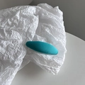 Detail of teal macaron hair clip with fine texture on white crinkled paper background - Fresh Green