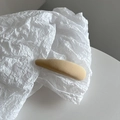 Détail de la texture en tissu côtelé kaki sur une pince à cheveux minimaliste - Abricot