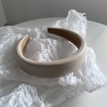 Dettaglio del cerchietto in pelle beige imbottito con finitura testurizzata antiscivolo - Bianco Sporco