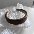 Dettaglio di cerchietto in pelle marrone scuro imbottito con fodera interna antiscivolo - Cachi