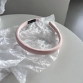 Detalle macro de una diadema de tela rosa claro hecha a mano con una etiqueta tejida negra - Rosa