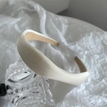 Detail of a padded cream sponge headband with matte satin finish and non-slip inner grip - Off-white